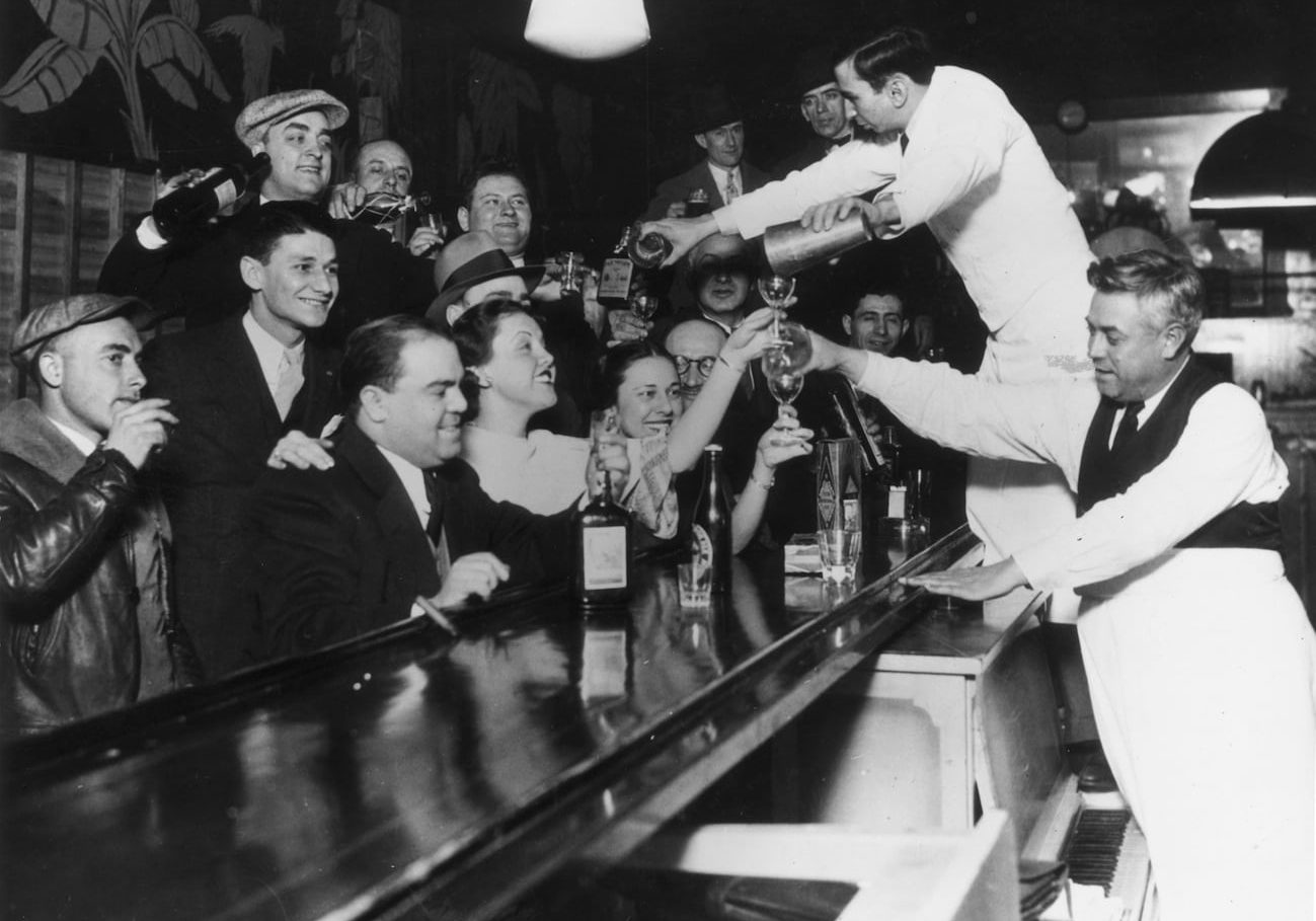 Bartenders at Sloppy Joe's bar pour a round of drinks on the house for a large group of smiling customers as it was announced that the 18th Amendment had been repealed and Prohibition had been removed from the US Constitution after 13 years, Chicago, Illinois  (Photo by American Stock/Getty Images)